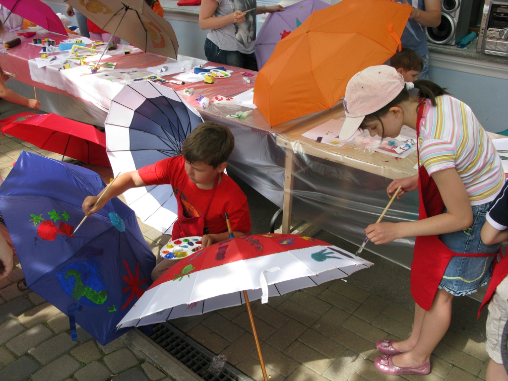 Дети увлеченно превращают обычные зонтики в веселые